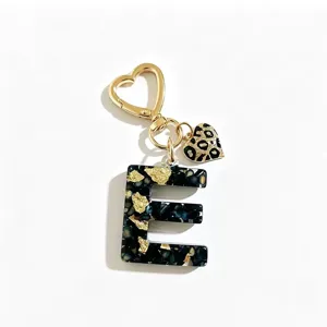 Detailansicht Harz Buchstabe E Schlüsselanhänger, schwarze Goldfolie mit Leopardenherz.