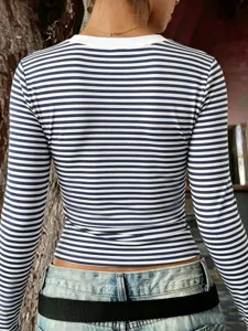 Detail view of the back of a slim-fit blue and white striped long sleeve top with a necklace.