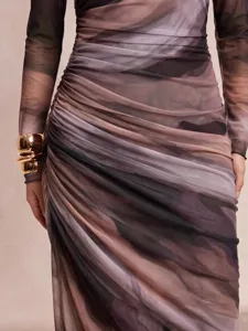 Close-up of women's long sleeve mesh dress with elegant marble print and ruched detailing.