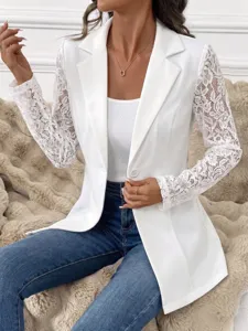 Gedetailleerd overzicht van witte blazer met kanten mouwen, fijne borduursels en slim fit pasvorm.