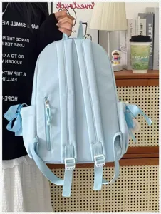 Zaino scolastico azzurro con fiocchi laterali, spallacci resistenti e comoda tasca frontale con zip.