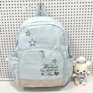 Zaino scolastico azzurro chiaro con ricamo di stelle, tasca frontale e pratici scomparti laterali.