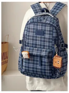 Detailed view of the blue plaid school backpack featuring cute toast plush pendants attached.