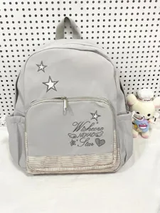 Dettaglio di zaino scolastico grigio casual con delicato ricamo di stelle e tasca frontale.