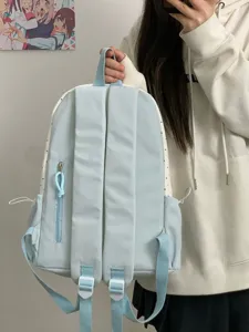 Detail shot showing the back straps and side polka dot pattern of the cute blue backpack.