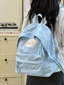 Bonita mochila escolar azul claro con parche de oso y bordado, ideal para salidas informales.