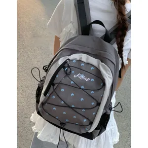 Vista dettagliata dello zaino elegante a pois con coulisse e grande capacita per la scuola.