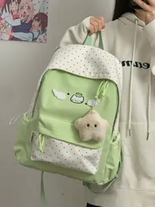 Cute green polka dot student backpack detail showing wing cat embroidery and star plush pendant.