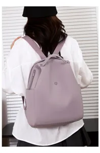 Detailed rear view of a minimalist light purple nylon backpack showing shoulder straps and shape.