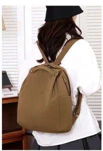 Detailed view of the lightweight brown nylon backpack, showing back-wearing style and durable straps.