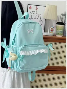 Dettaglio zaino verde menta con grazioso fiocco, bordo in pizzo e tasche laterali utili.