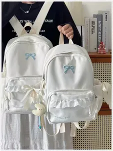 Vista dettagliata del simpatico zaino scolastico bianco con delicato fiocco blu e pizzo.