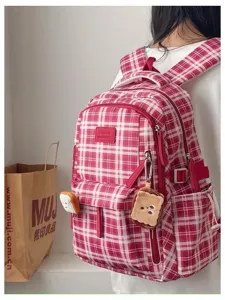 Close-up detail of the vintage red plaid student backpack, featuring cute toast pendants.