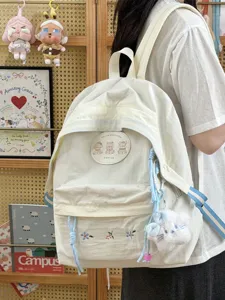 Mochila escolar japonesa linda con insignia de oso y bordado floral para viajes diarios.