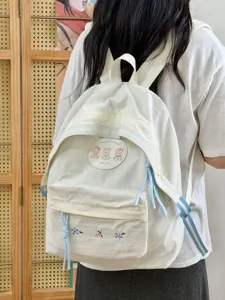 Vista detallada de la bonita mochila escolar coreana con bordado floral y insignia.