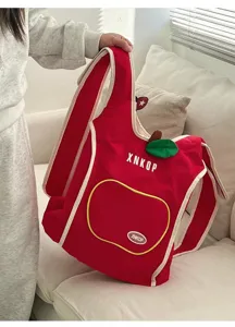 Vista detallada de la linda mochila chaleco de lona en forma de manzana roja con borde crema.