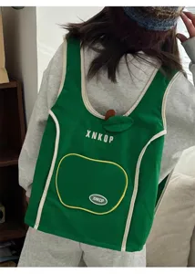 Vista detallada de la bonita mochila chaleco verde en forma de manzana con ribete blanco.