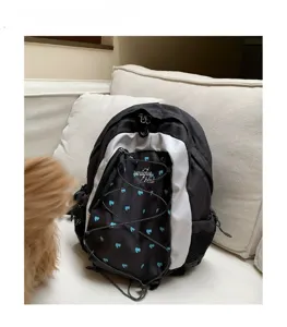 Detail view of the colorblock backpack featuring blue heart prints and front cord pocket.