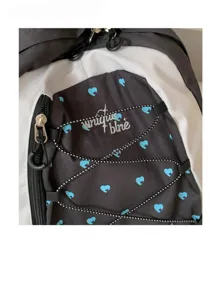 Close-up detail view of Korean style black and white color block backpack with cute blue heart pattern.