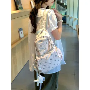 Detailed view of cute pink polka dot backpack, lightweight student school bag with cute star pendant.
