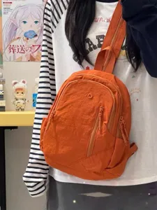 Casual mini backpack for outdoor travel, stylish orange nylon daypack for men and women.