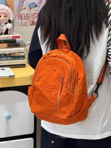 Compact orange nylon backpack for casual travel, lightweight daypack with multi zippers.