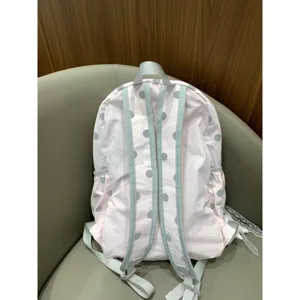Back view detail of a cute pink and grey polka dot student backpack with adjustable straps.