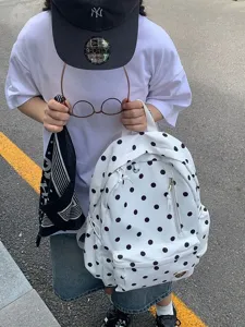 Vista dettagliata dello zaino casual bianco a pois neri perfetto per lo stile quotidiano.