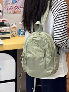 Lightweight casual small backpack in light green nylon, detail view showing daily wear.