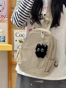 Small nylon casual backpack with cute black cat plush pendant, lightweight daily travel bag.