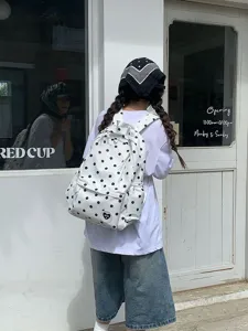 Vista dettagliata lifestyle di uno zaino a pois trendy indossato all'aperto in città.