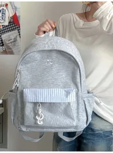 Zaino grigio da studente in stile coreano con tasca a righe e ciondolo per la scuola.