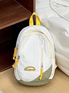 Vista detallada de una mini mochila de moda en blanco con correas amarillas y base verde.