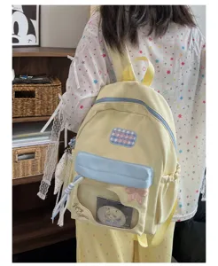 Vue détaillée du joli sac itabag jaune et bleu avec fenêtre transparente et broderie de nœud.