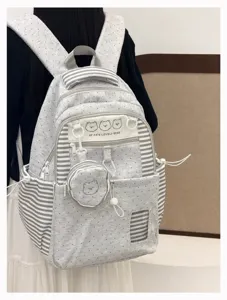 Detailed view of grey dotted backpack with stripes, cute bear patch and attached pouch.