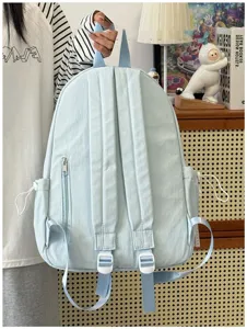 Zaino in tela azzurra con tasche multiple, perfetto per la scuola e l'uso casual quotidiano.