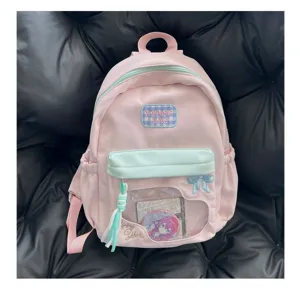 Détail de sac à dos ita rose avec fenêtre transparente, broderie nœud et badge mignon.