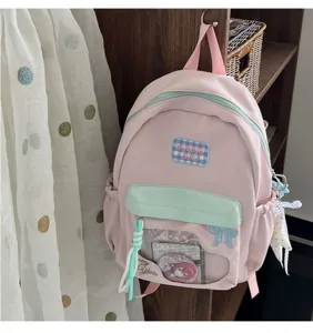 Vue détaillée du sac à dos rose ita avec fenêtre transparente, broderie de nœud et style.