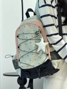 Detailansicht eines stylischen Canvas-Rucksacks mit blauen Herzen und Sternanhänger.