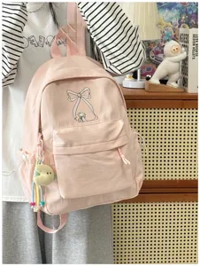 Vista dettagliata dello zaino rosa carino con fiocco, borsa scolastica dolce con ciondolo peluche.