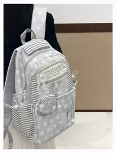 Detailed view of Korean style star pattern school backpack with cute bear pendant.