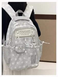 Close-up detail of grey star pattern backpack with cute bear graphic and multi-pocket design.
