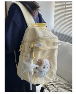 Clear front pocket detail of the cute yellow polka dot ita bag, showing plush doll inside.