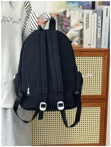 Zaino scolastico nero in stile coreano con grande capacità, spallacci e tasche laterali.