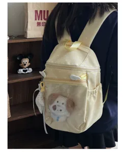 Detail shot of a yellow polka dot ita backpack with a clear transparent doll window display.