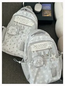 Detailed view of the gray star pattern backpack with cute bear graphic and striped pocket trim.