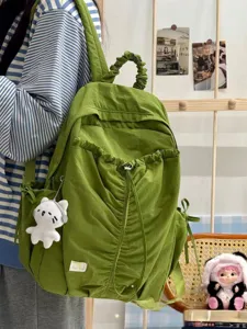 Detailed view of the stylish green ruched casual backpack with cute cat pendant design.