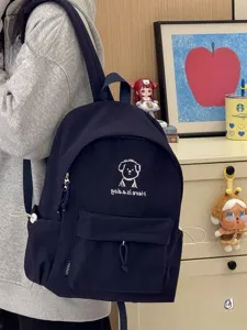 Cute cartoon dog embroidered navy blue canvas backpack, minimalist school bag for students.