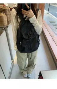 Black nylon casual backpack with drawstring and front pockets for daily commute travel.