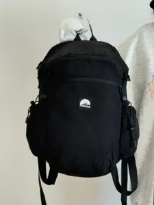 Vue détaillée du patch avant et de la structure fonctionnelle du sac à dos de voyage noir.